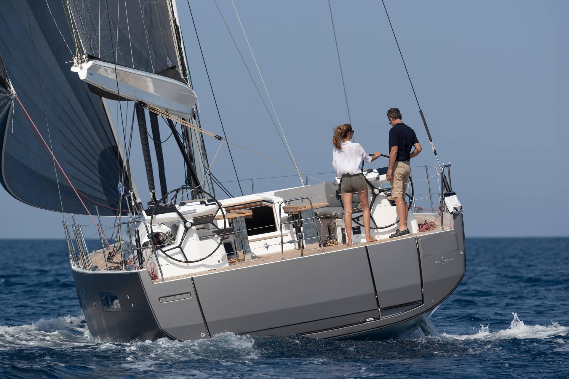 Backside of a Jeanneau 60 with grey body and sails
