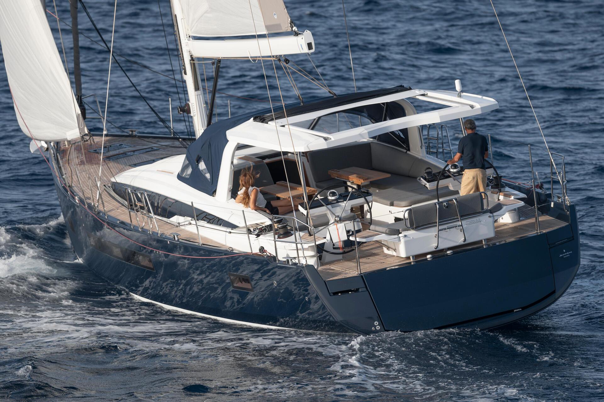a dark blue jeanneau 65 on the water