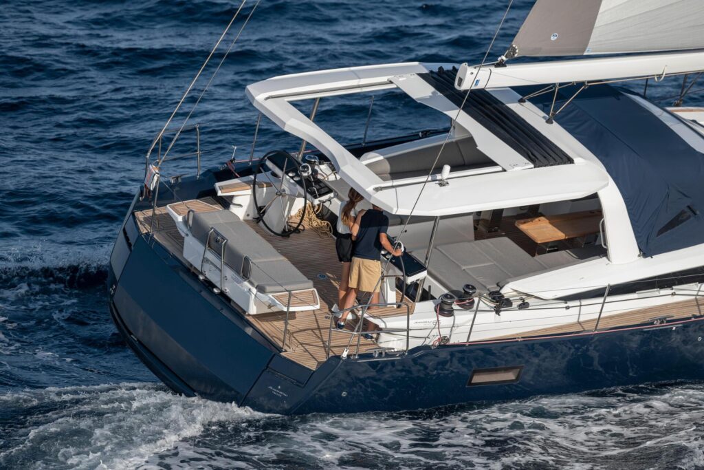jeanneau 65 with dark blue body with white accents and grey sails