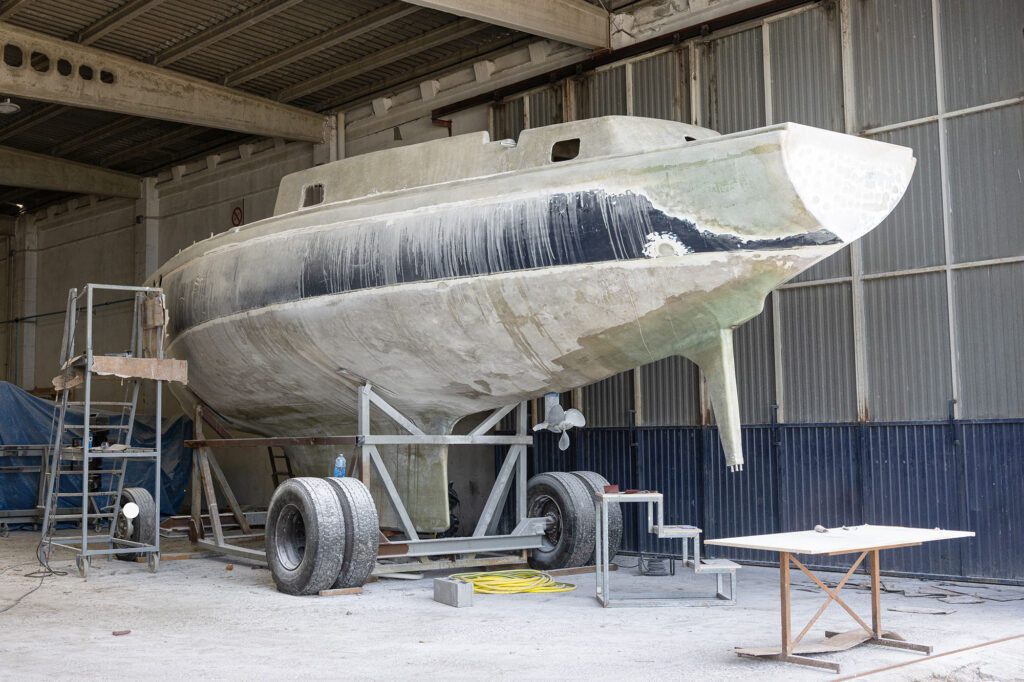 Fiberglass yacht being repaired at a shipyard. Boat restoration
