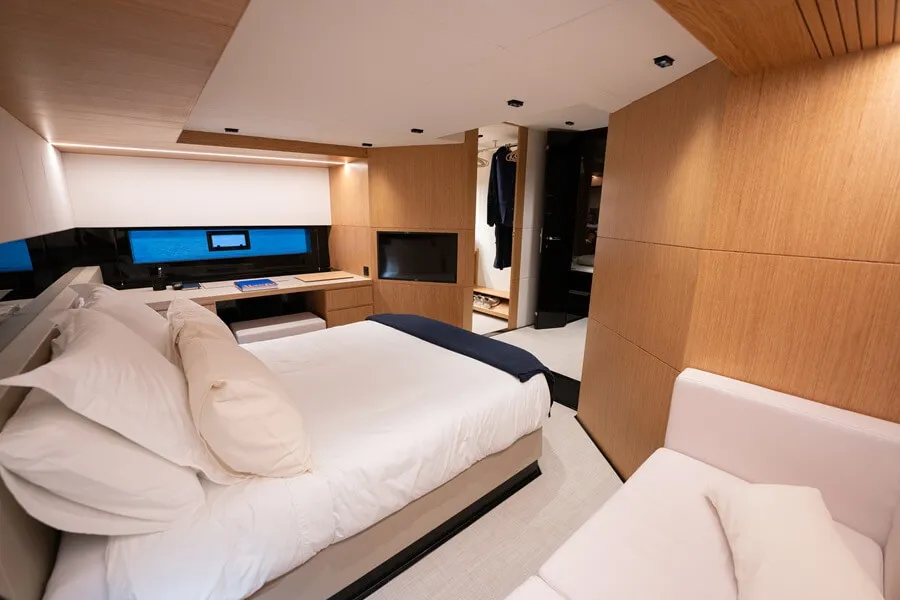 Interior salon and cabin consisting of a bed, closet, television, large desk, and sofa
